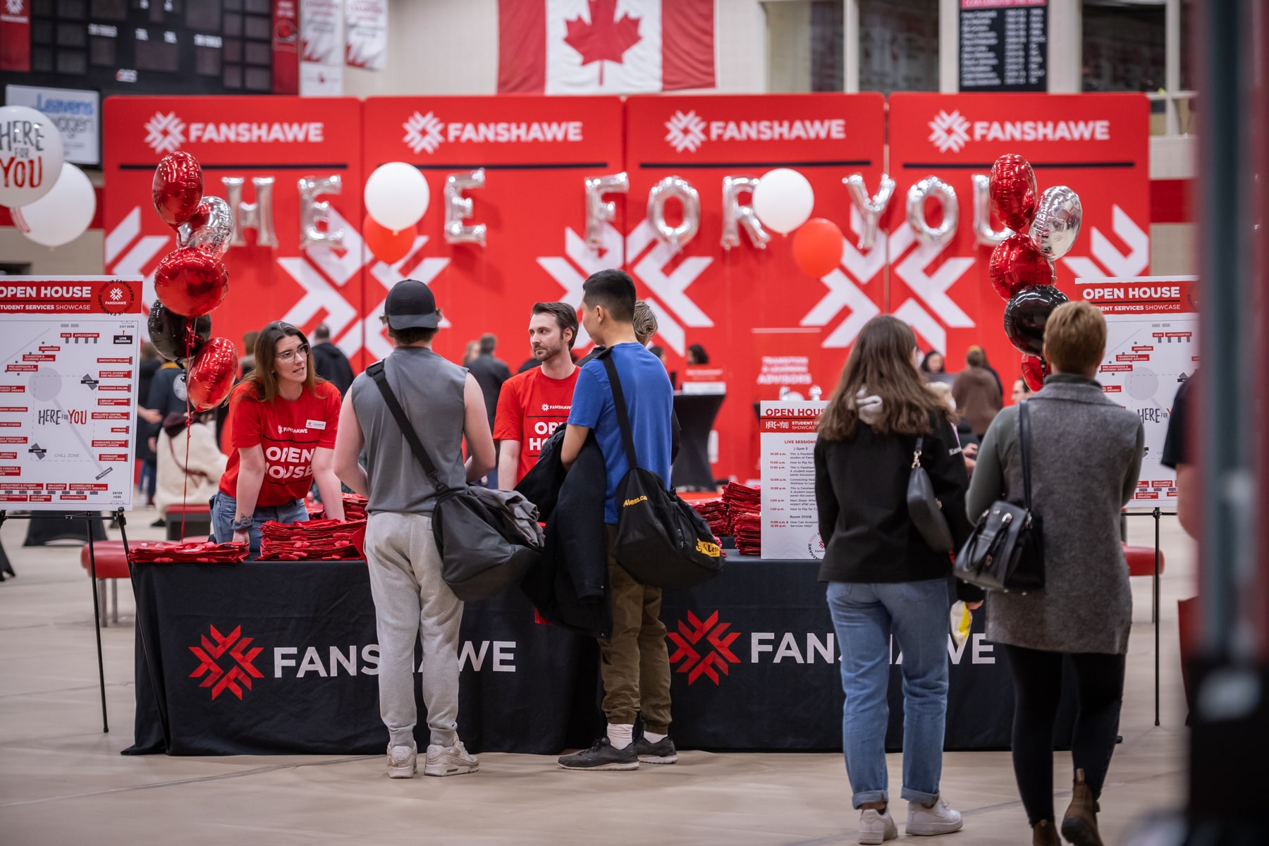 People standing at a welcome desk at open house