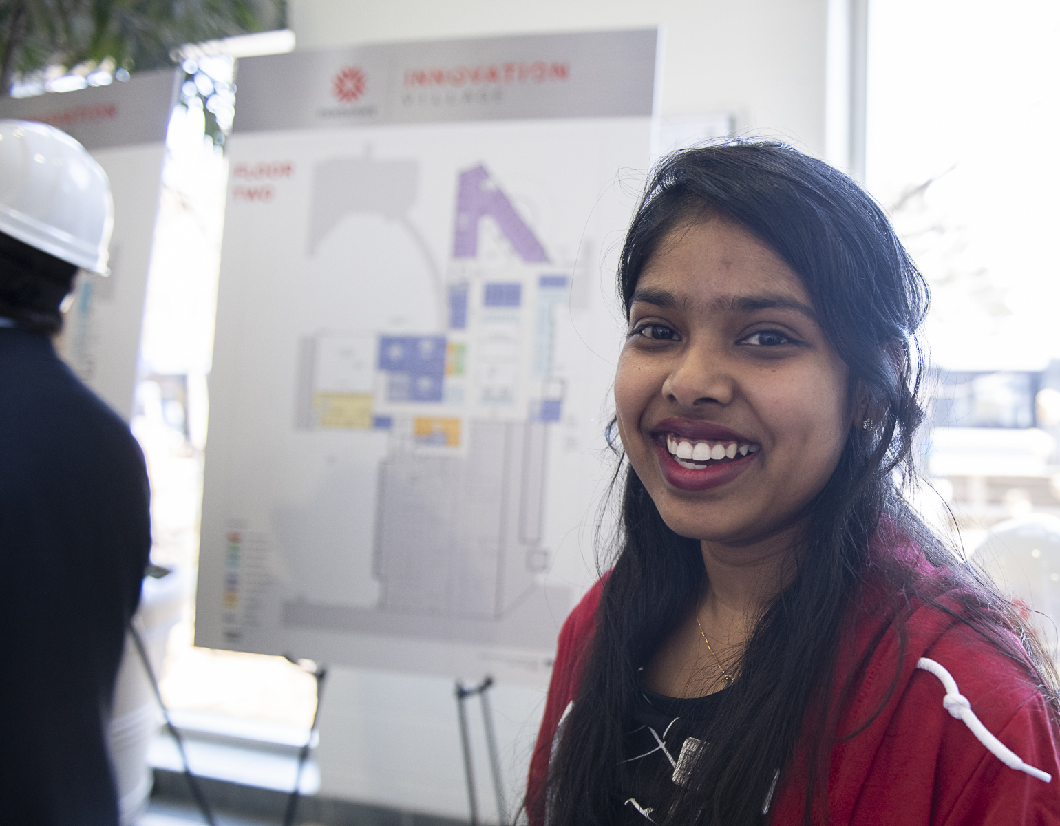 A student posing in front of their presentation