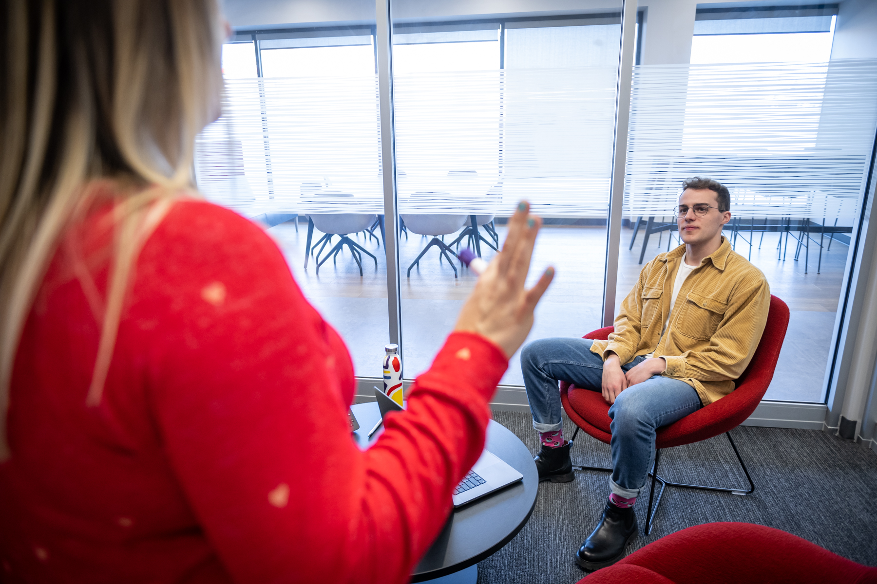 A male marketing student listening to a presentation at his co-op job