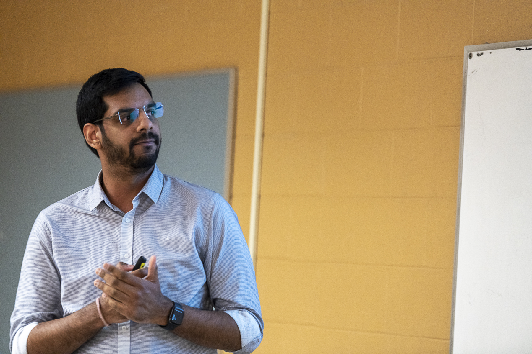 A male Indian student presenting in class.