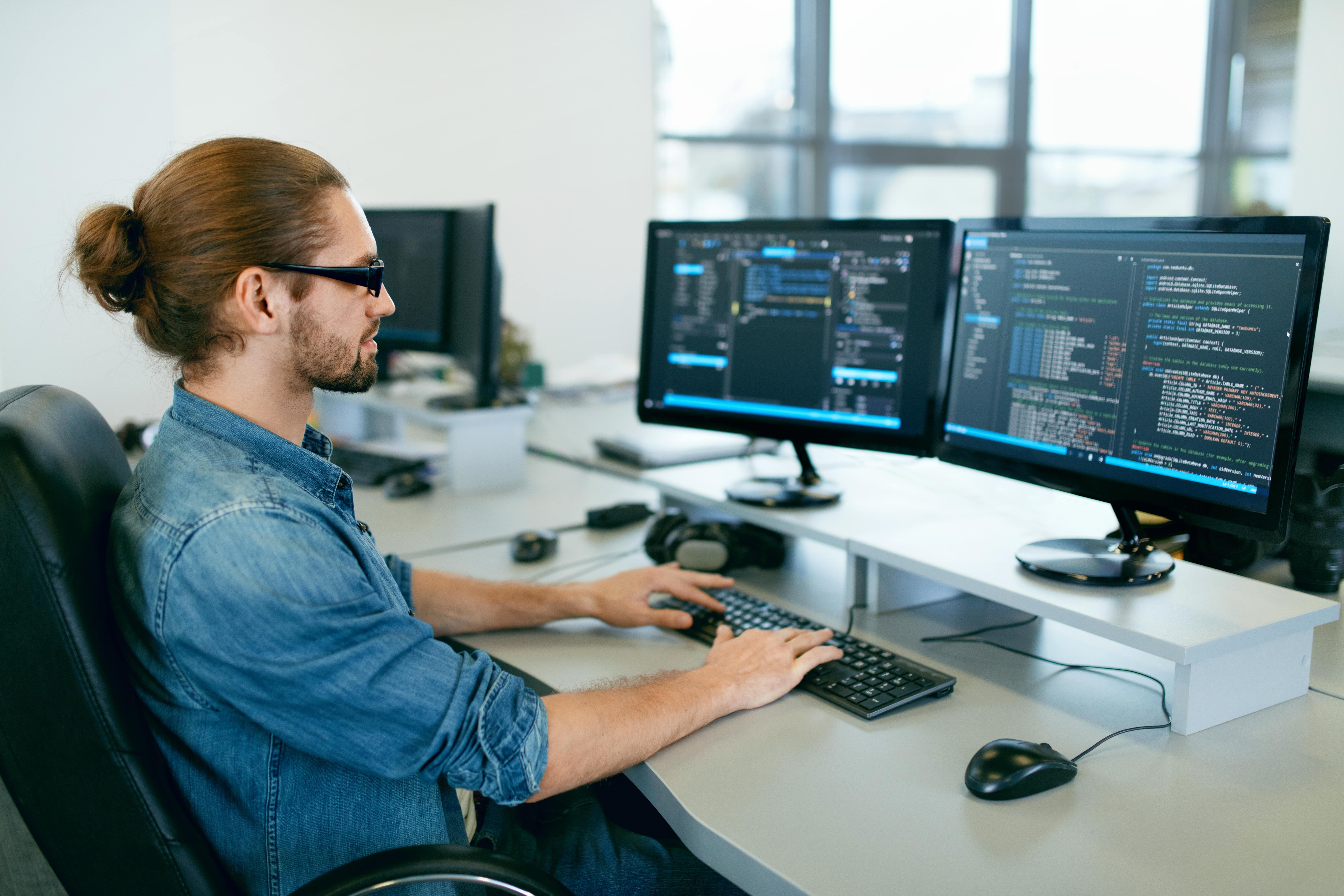 man looks at code on a computer