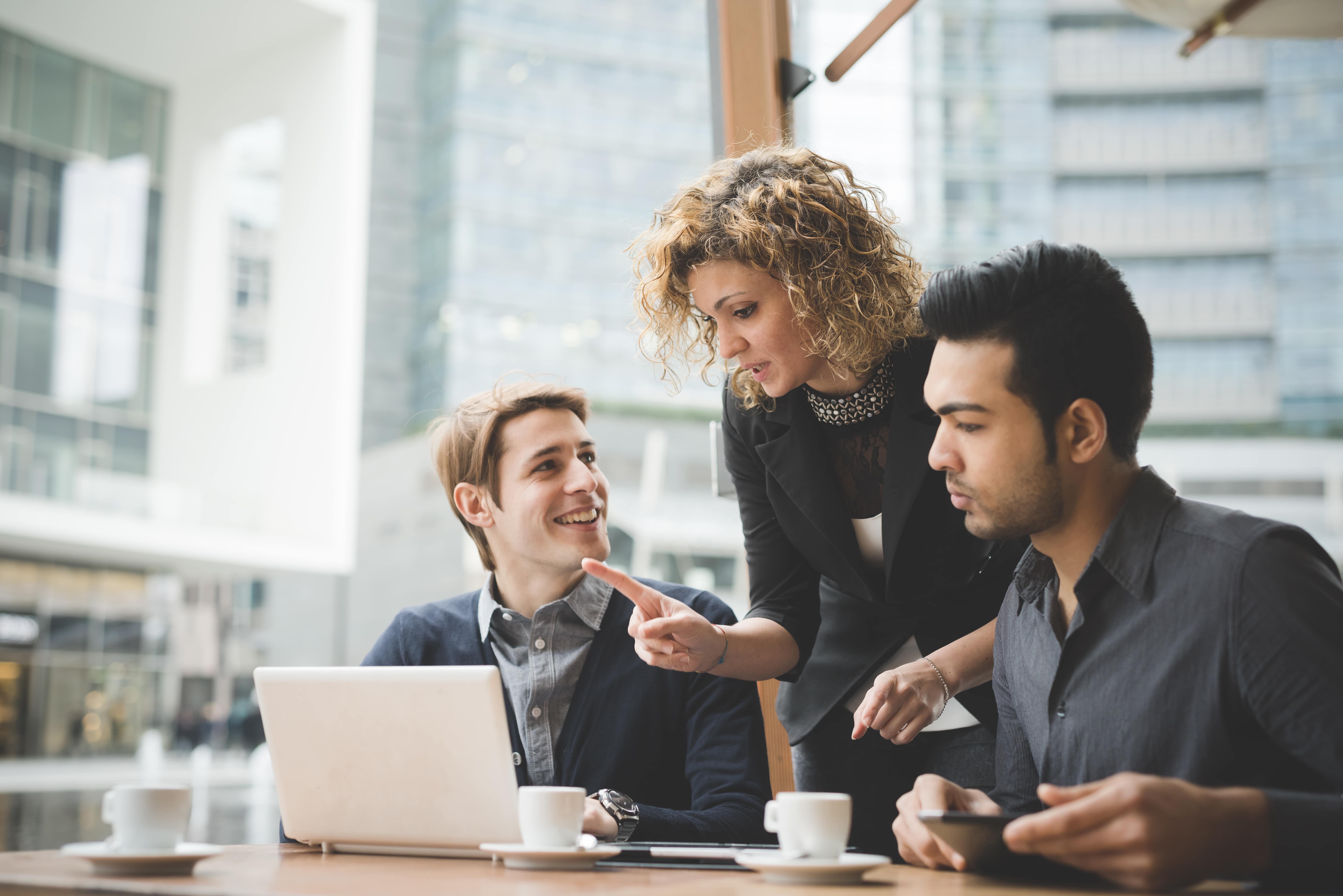 a group of people in front of a laptop