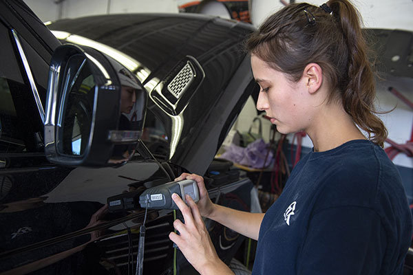 woman uses digital device to test vehicle