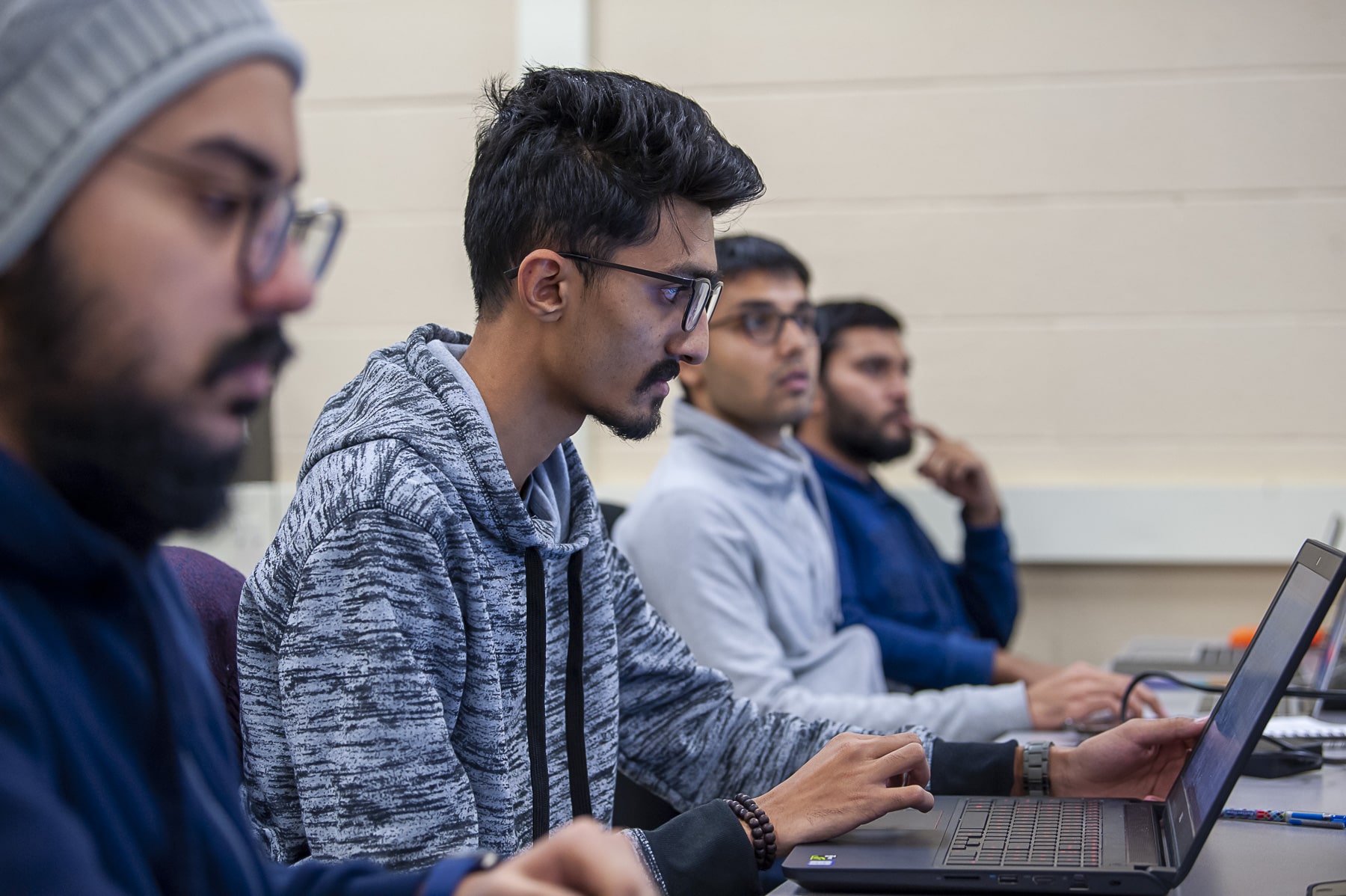 Technical systems analyst student sits looking at laptop