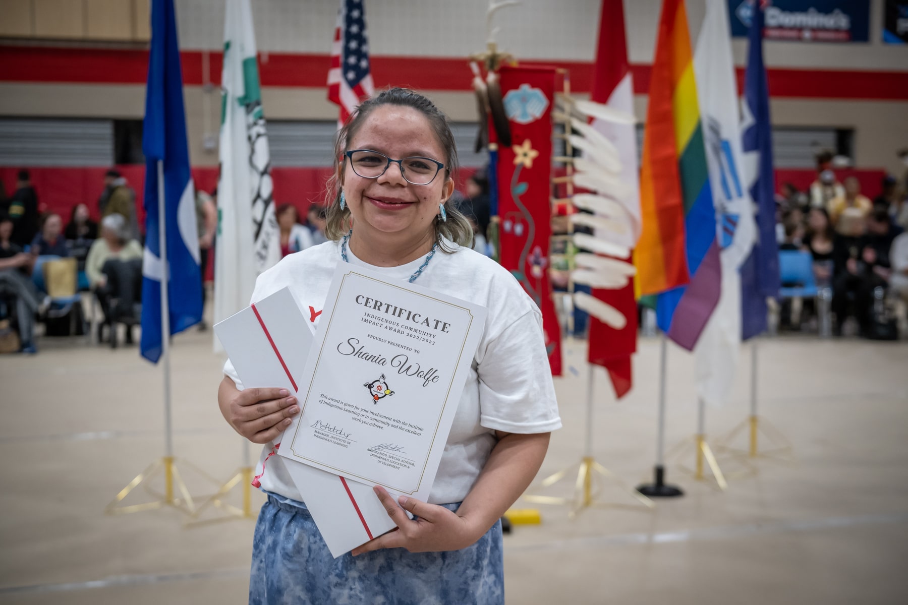 woman holds indigenous community impact award