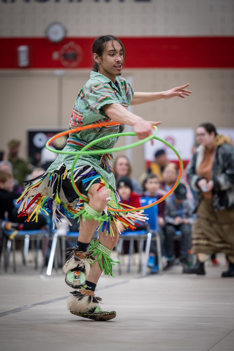 person dances in regalia with hoops