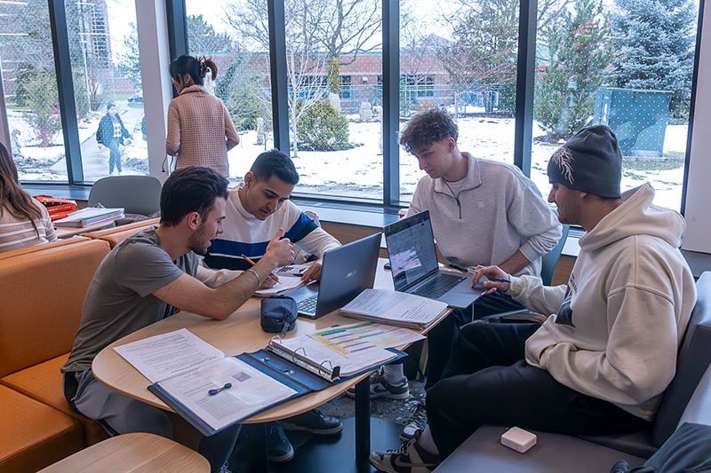 students sitting around table doing school work