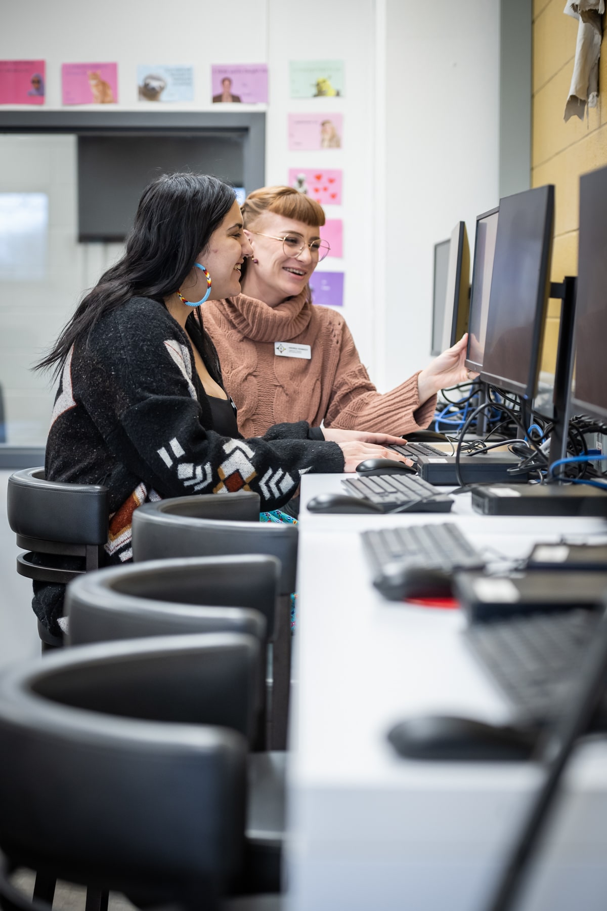 two women sit at computers in the institute of indigenous learning at fanshawe