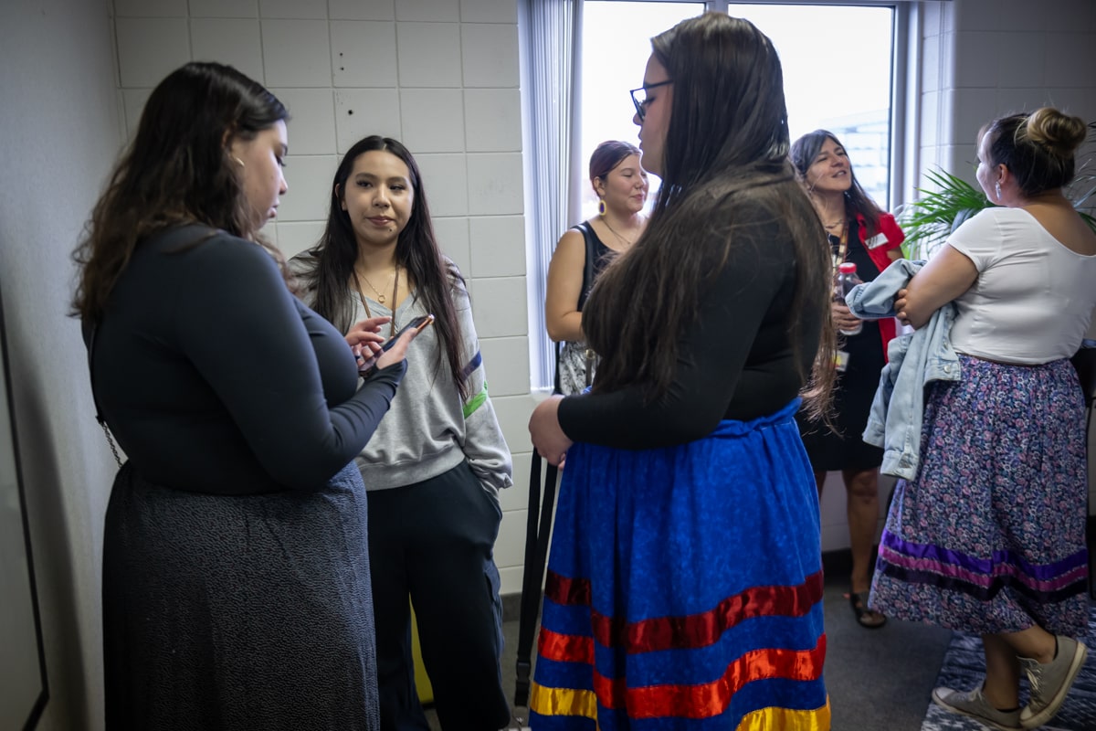 students stand in a circle chatting