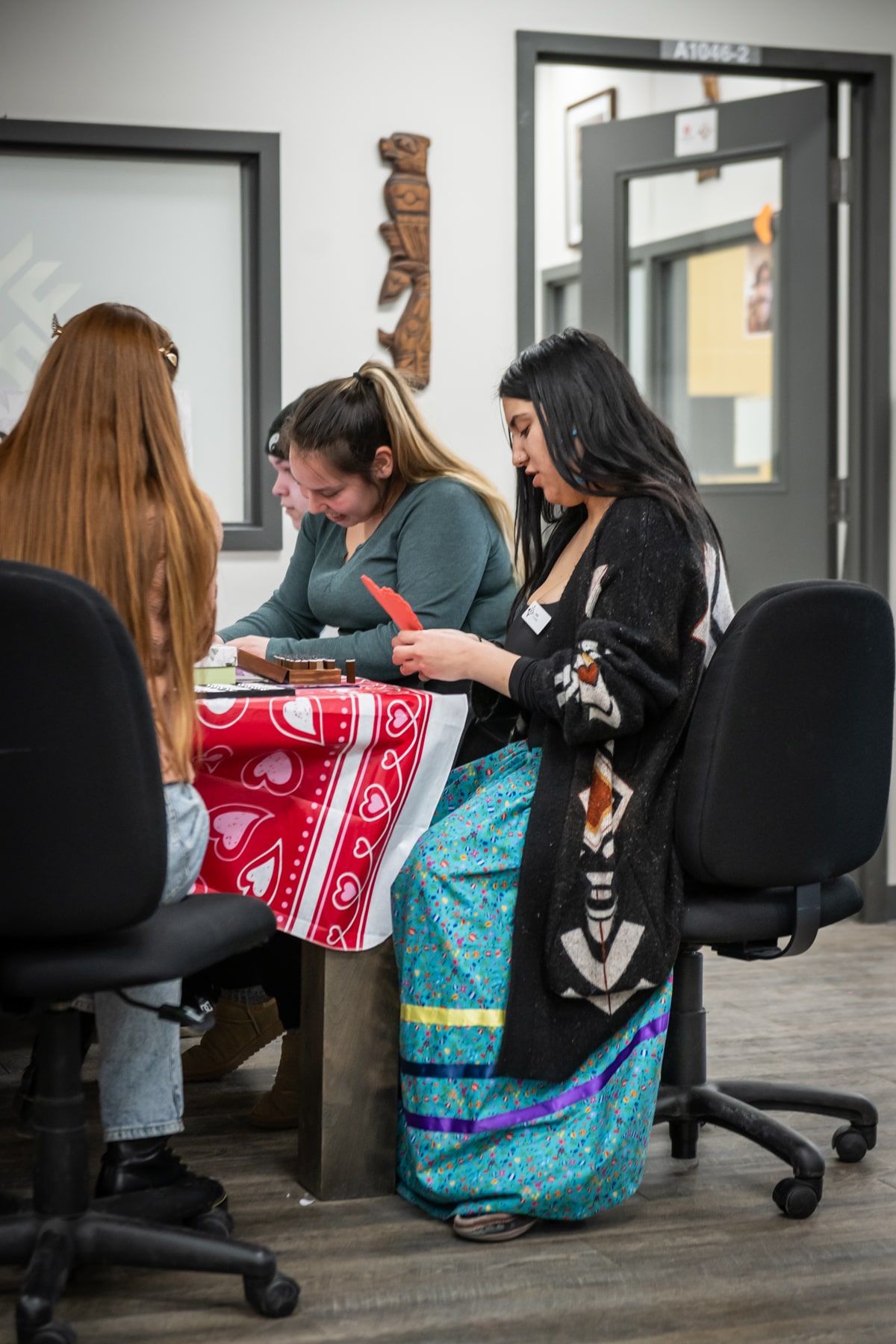 Institute of Indigenous Learning students sit around a table crafting