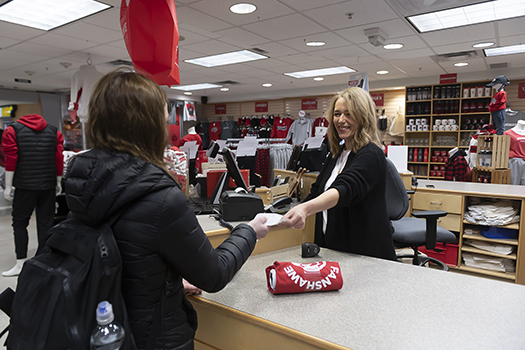 Retail Sales Supervisor retail sales supervisor behind counter hands customer a receipt
