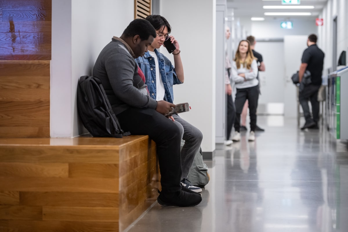 students sit in school hallway together