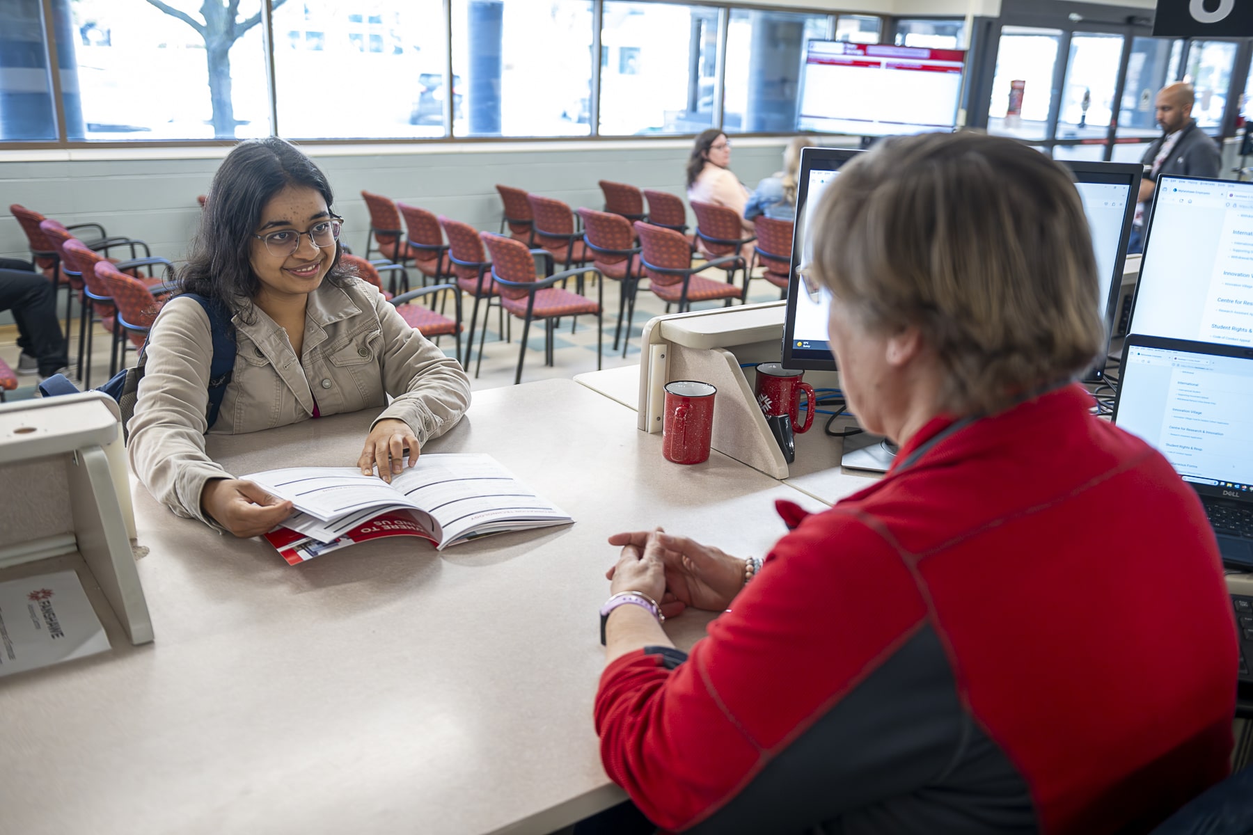 student talks to staff in registrar's office