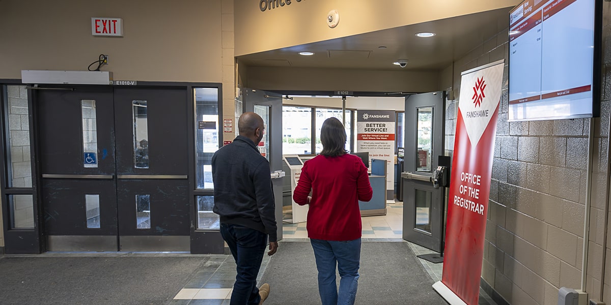 two people walk into Fanshawe's Office of the Registrar