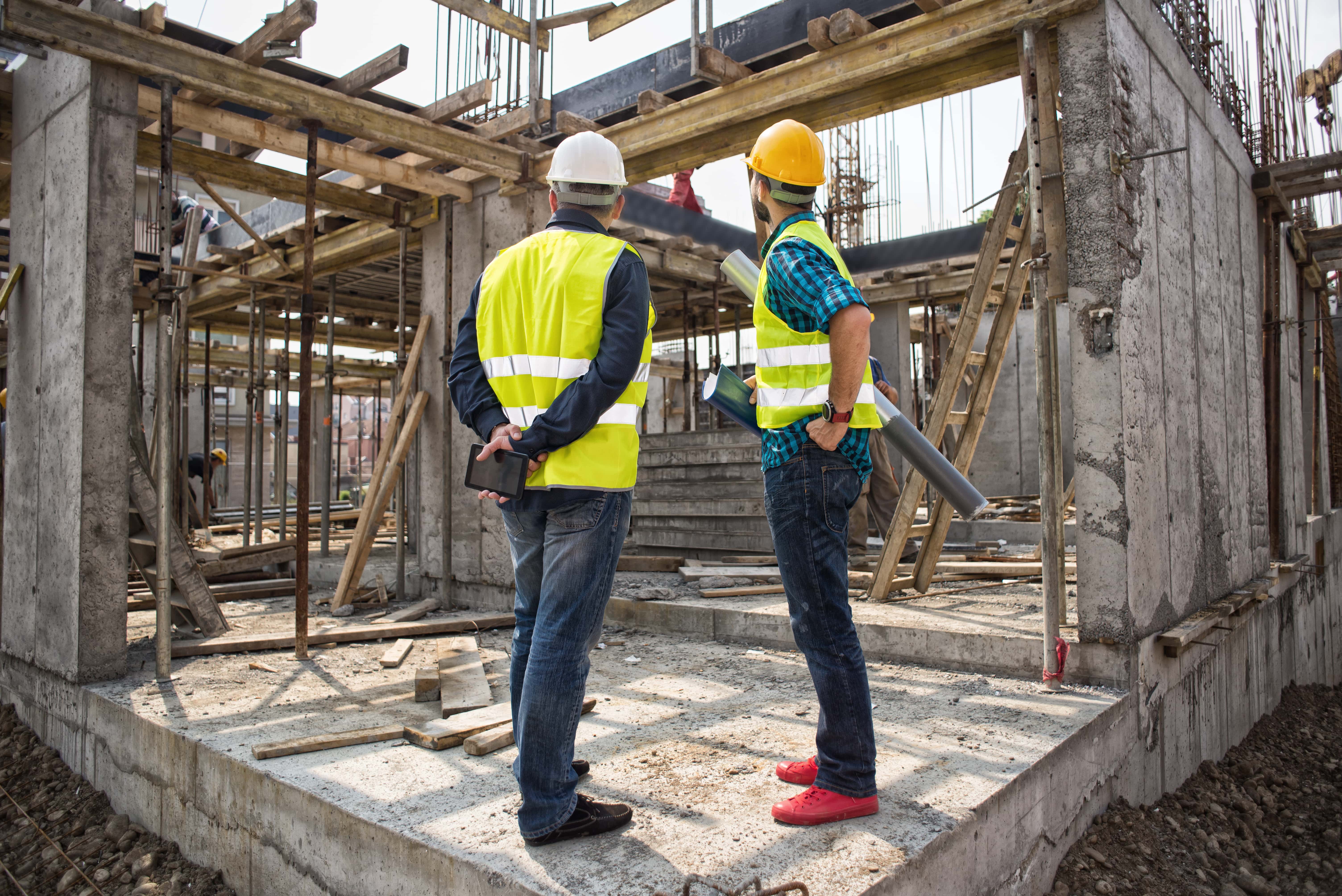 two construction workers observe a construction site
