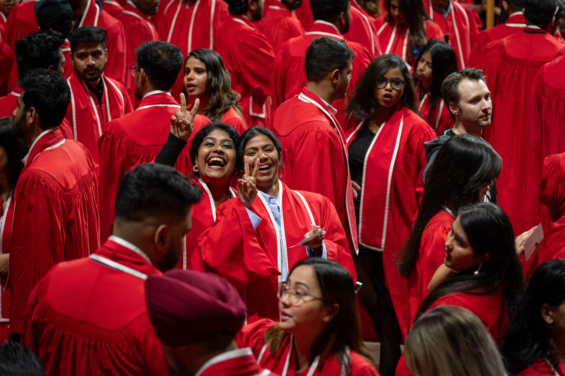 smiling graduates pose for cameras