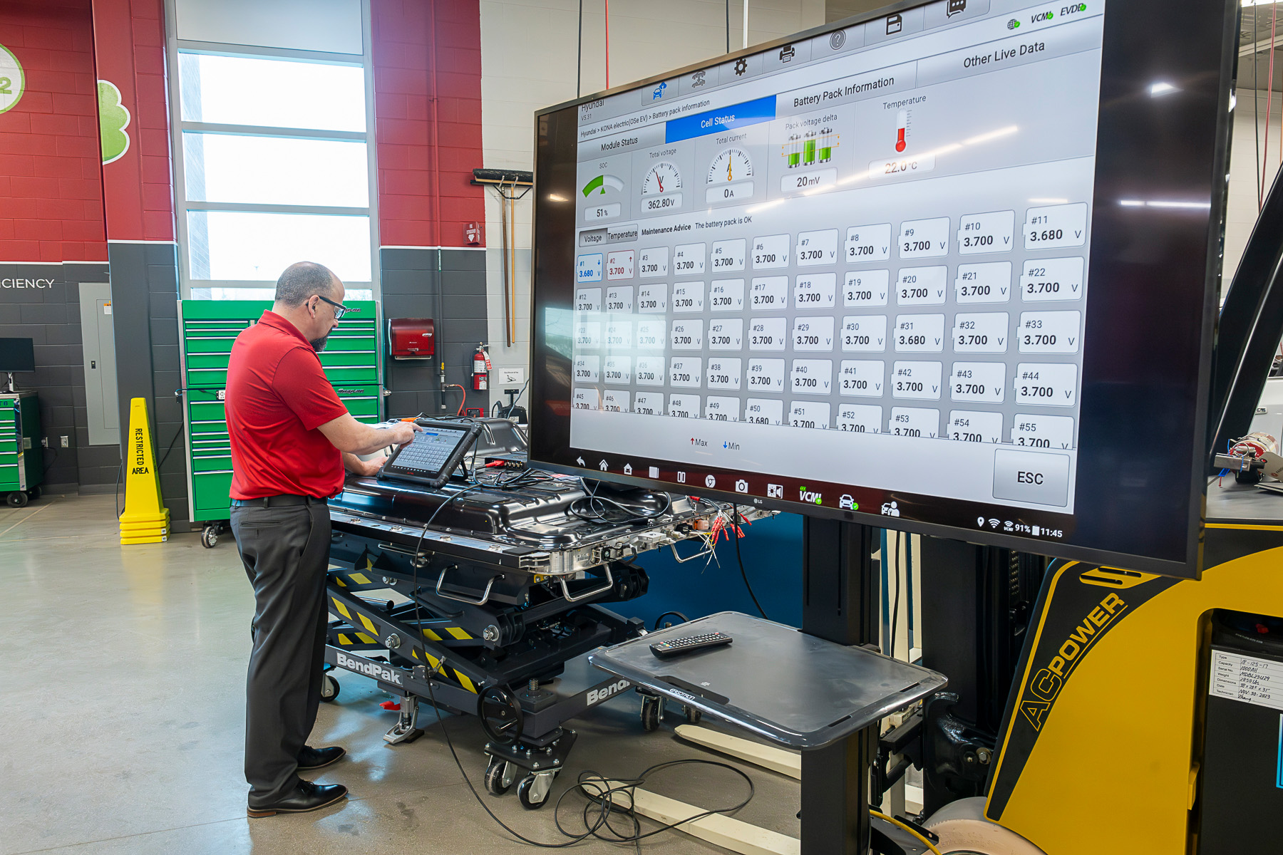 Green Vehicle Technician faculty member working on a car