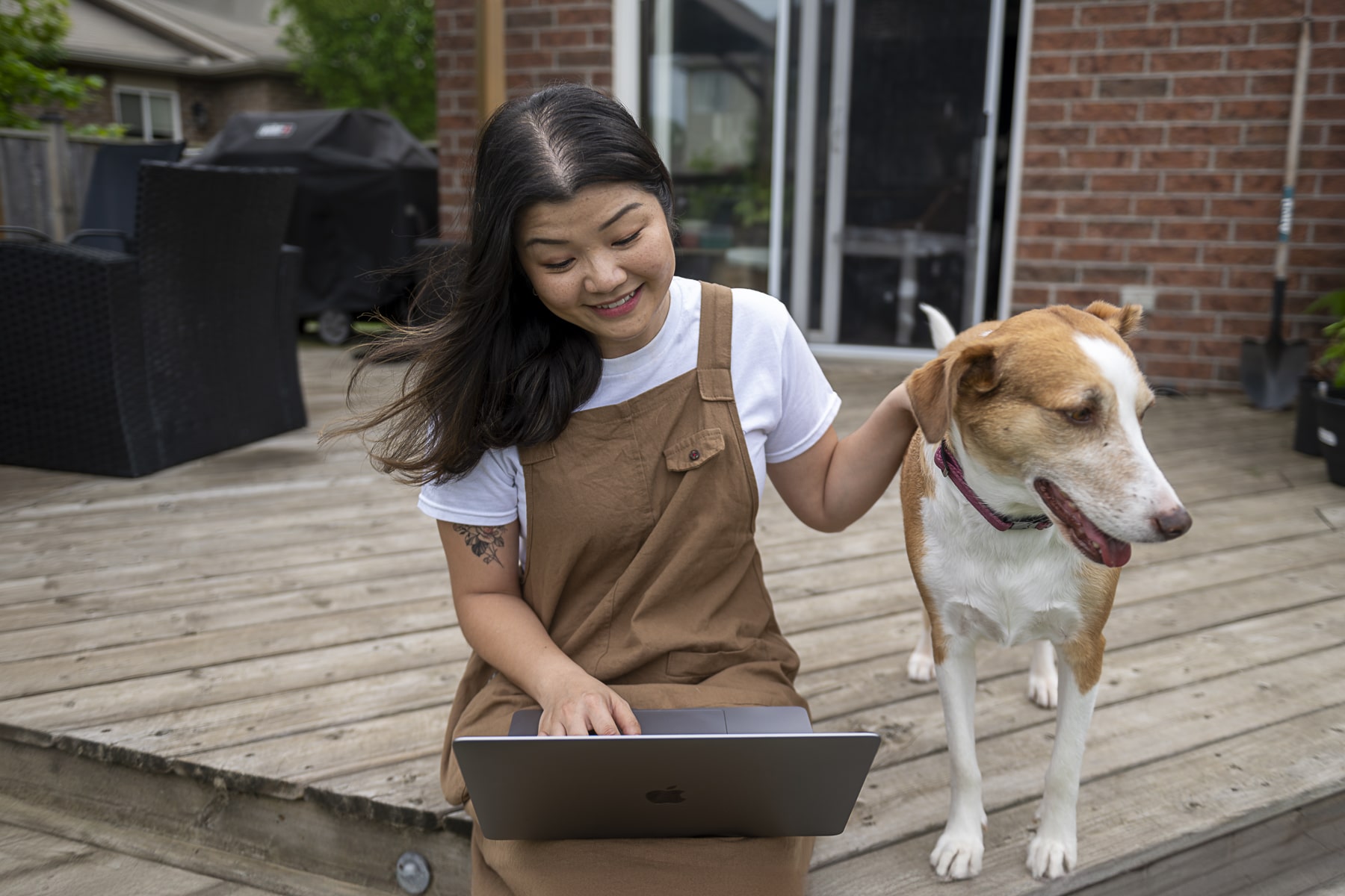student sits on porch studying next to dog