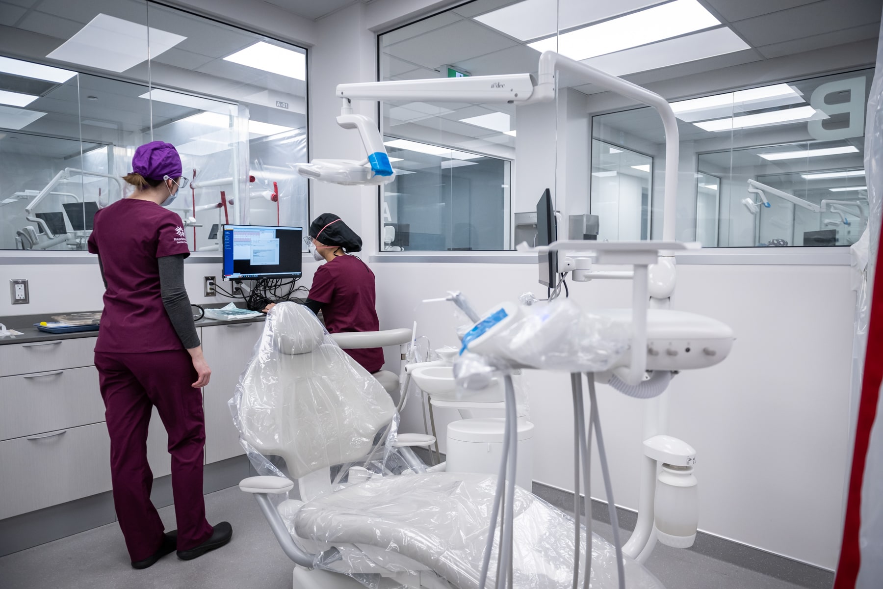 two dental workers stand in oral health clinic