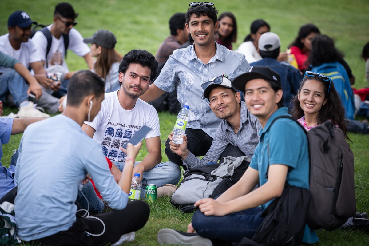 students sitting together on the grass at Fanshawe's orientation