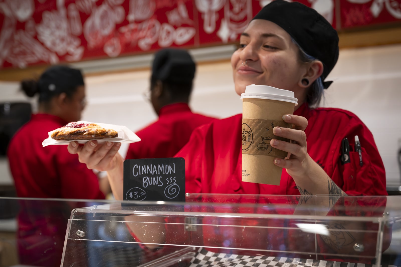 a barista is serving the coffee