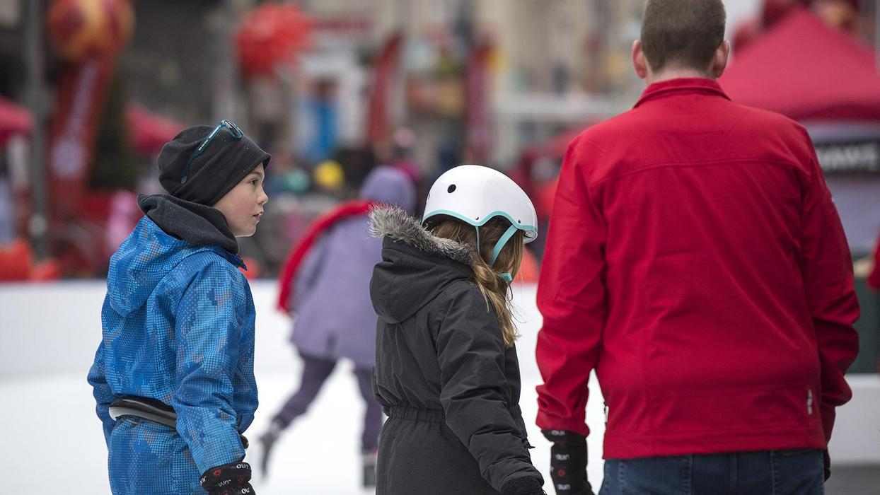 family skates together outdoors