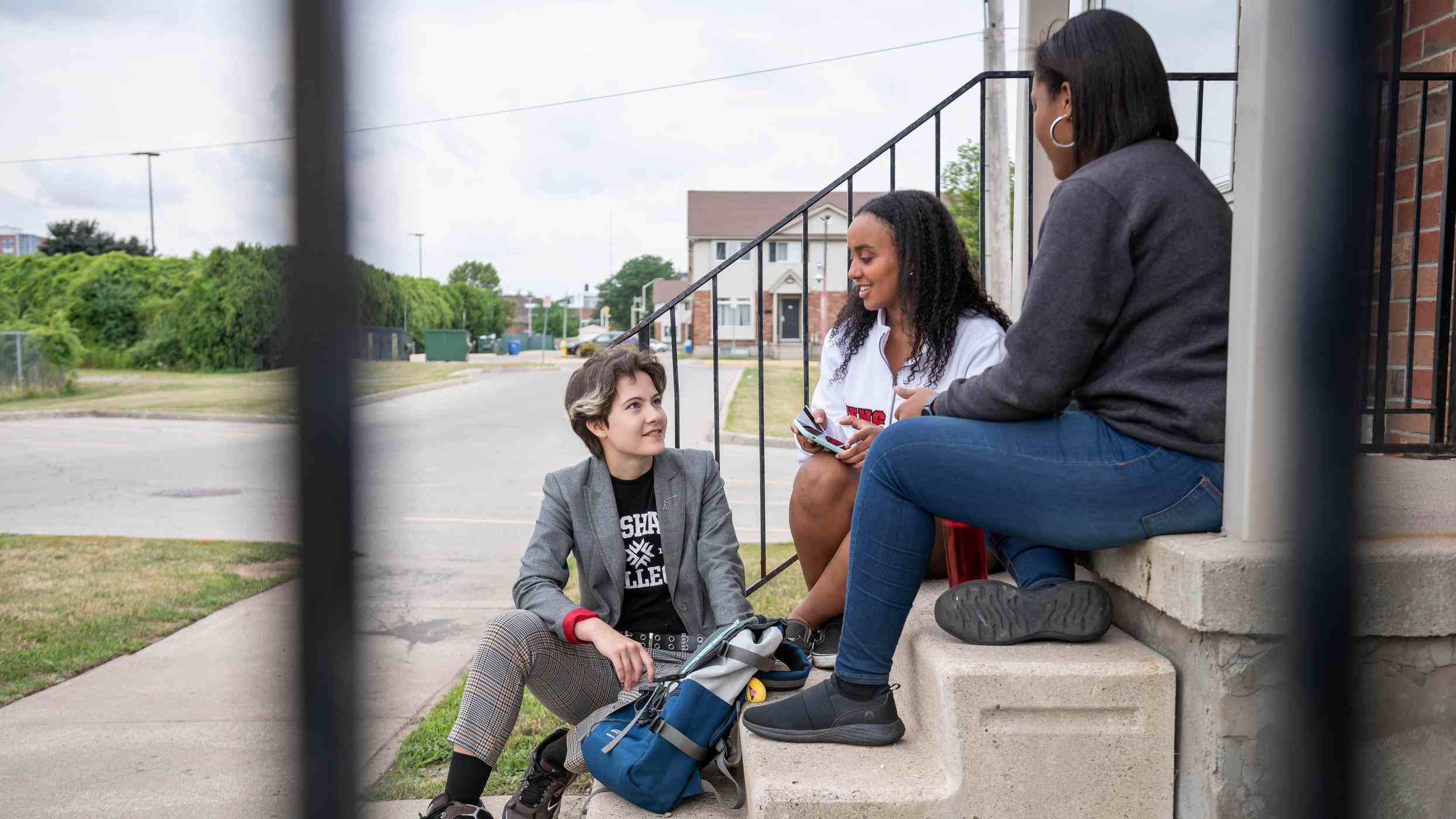 roommates sit together on steps having a discussion