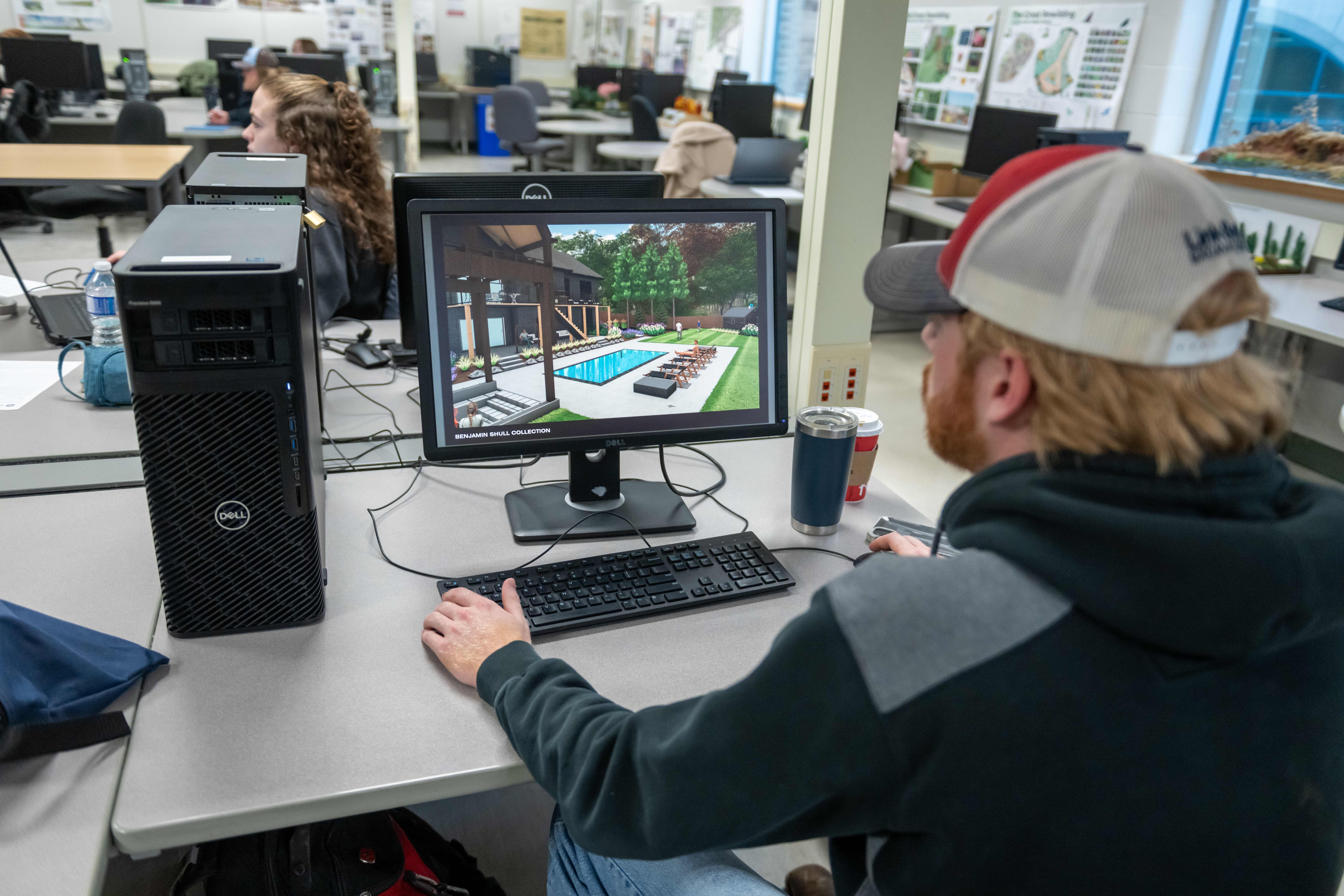 Photo of a student working on a computer rendering of a pool landscape design