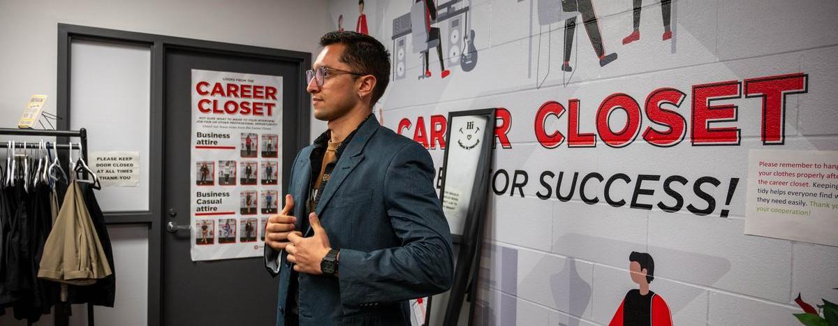 Photo of a student trying on a blazer at the career closet
