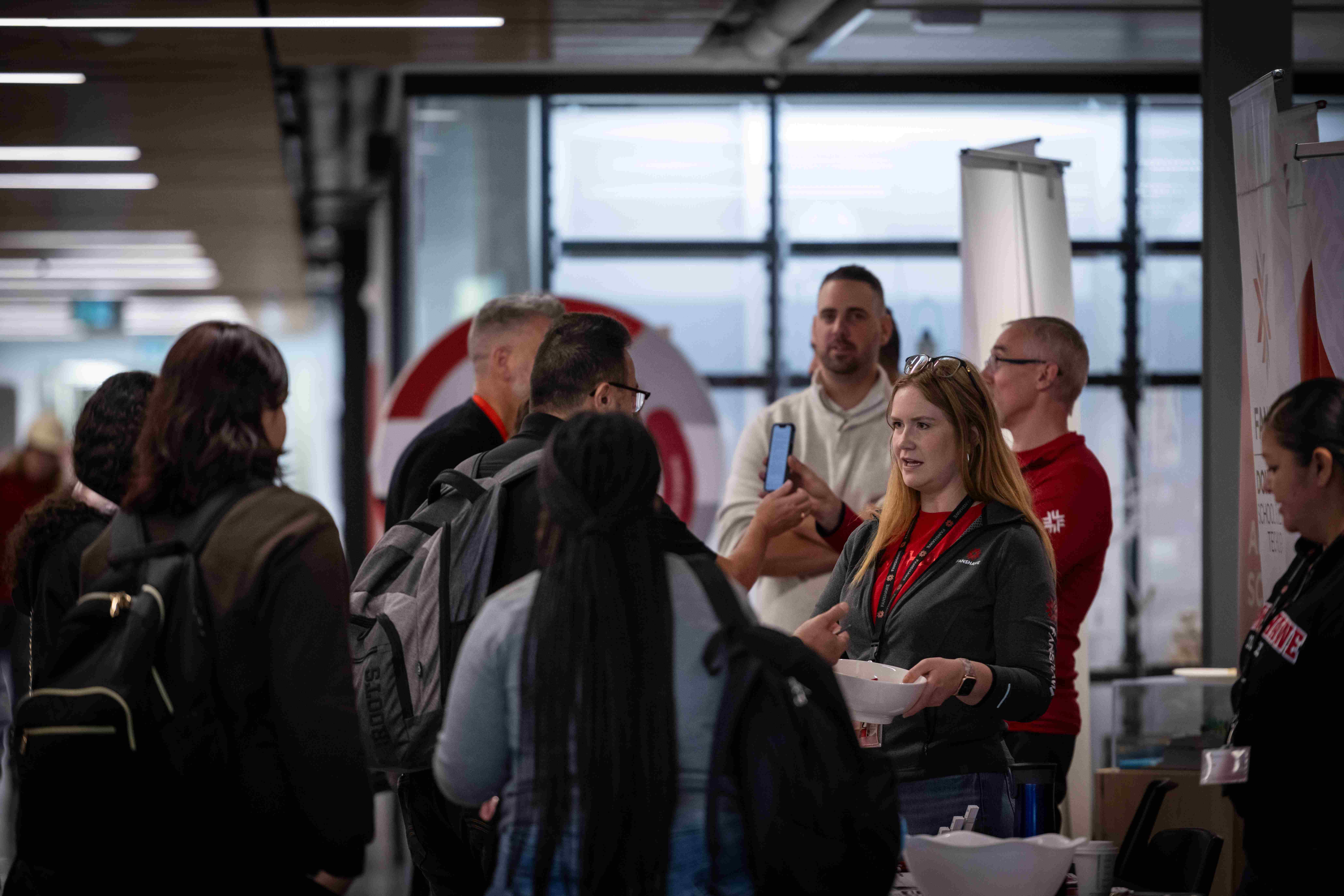A Fanshawe employee speaking with a student in a crowded environment at the pathways fair