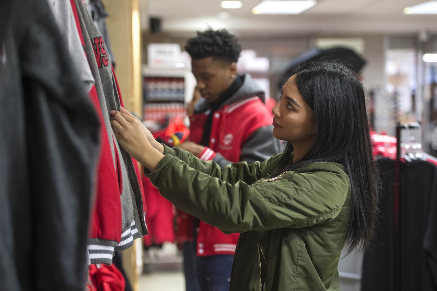 A student looking through sweaters at the falcon shop