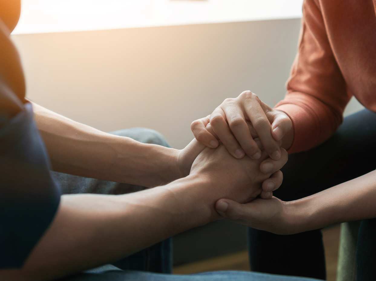 two people clasp hands
