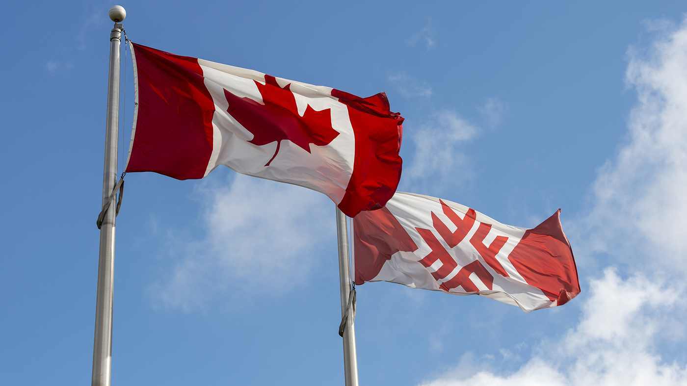 Fanshawe flag flies next to Canadian Flag
