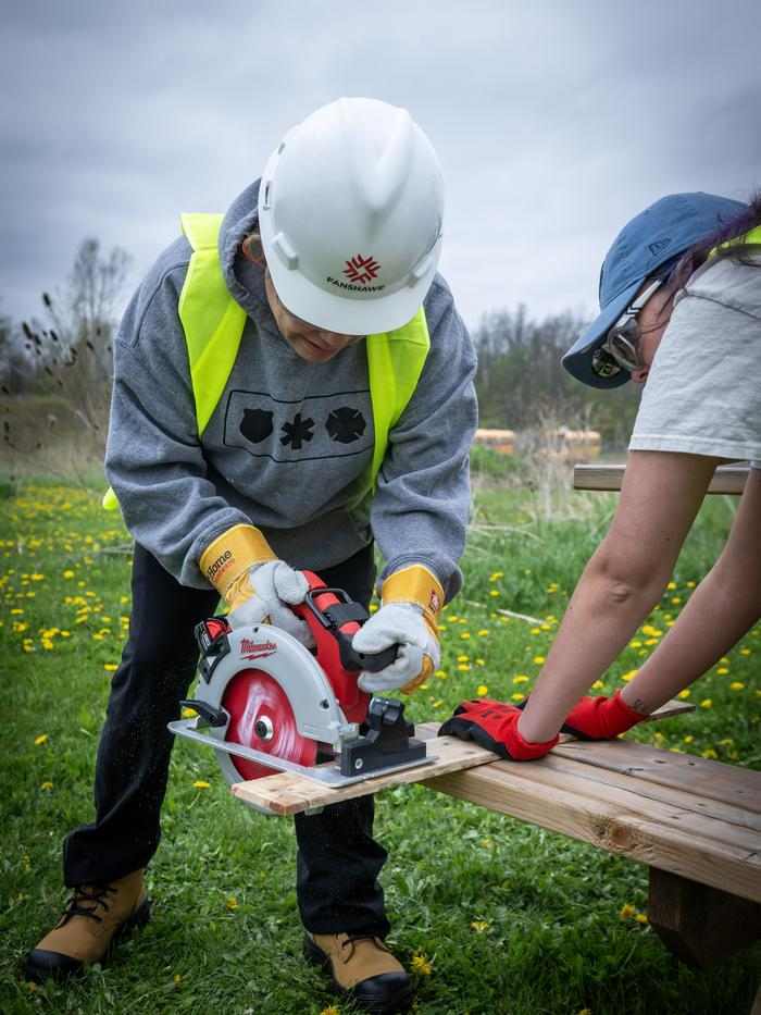 Award Eligibility trades workshop at the CTFN, a person uses a circular saw