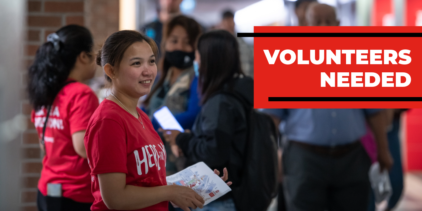 A student volunteer in a red shirt helping hand out campus maps