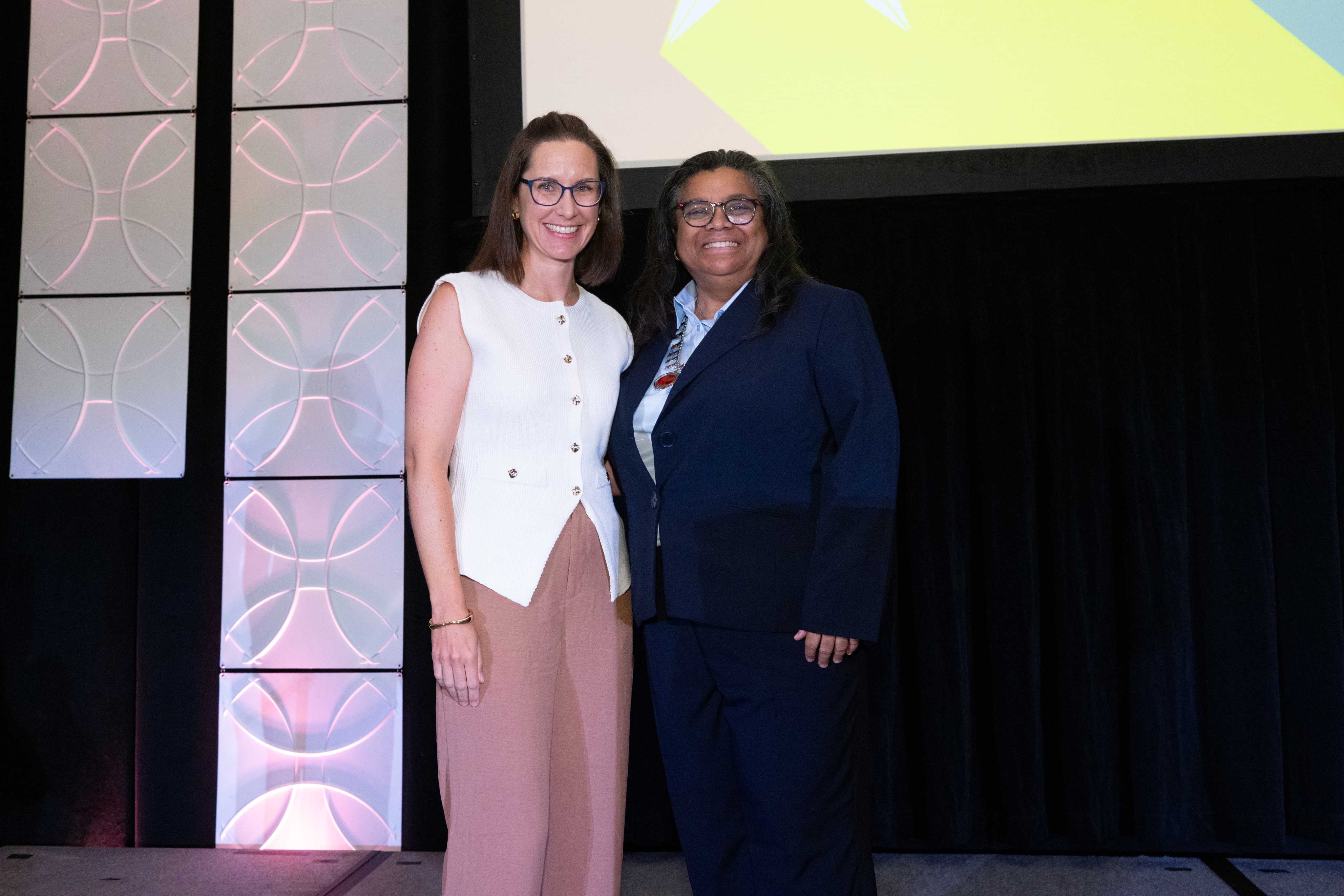 Tracie Skolny, left, receives the Teacher of the Year Award from the American Massage Therapy Association