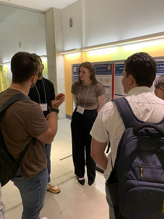 Allison Bergen discusses her team’s poster with conference attendees at the annual PSNA conference