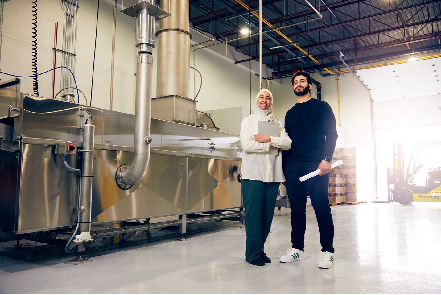 Photo of a women and a man posing for a photo in their factory