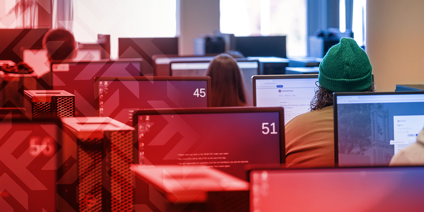 Photo from behind a row of students using computers in the test centre.