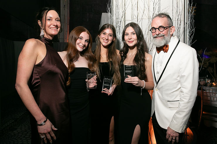 Three students in black dresses hold their PAVE awards as they celebrate with two representatives from the Hershey Company