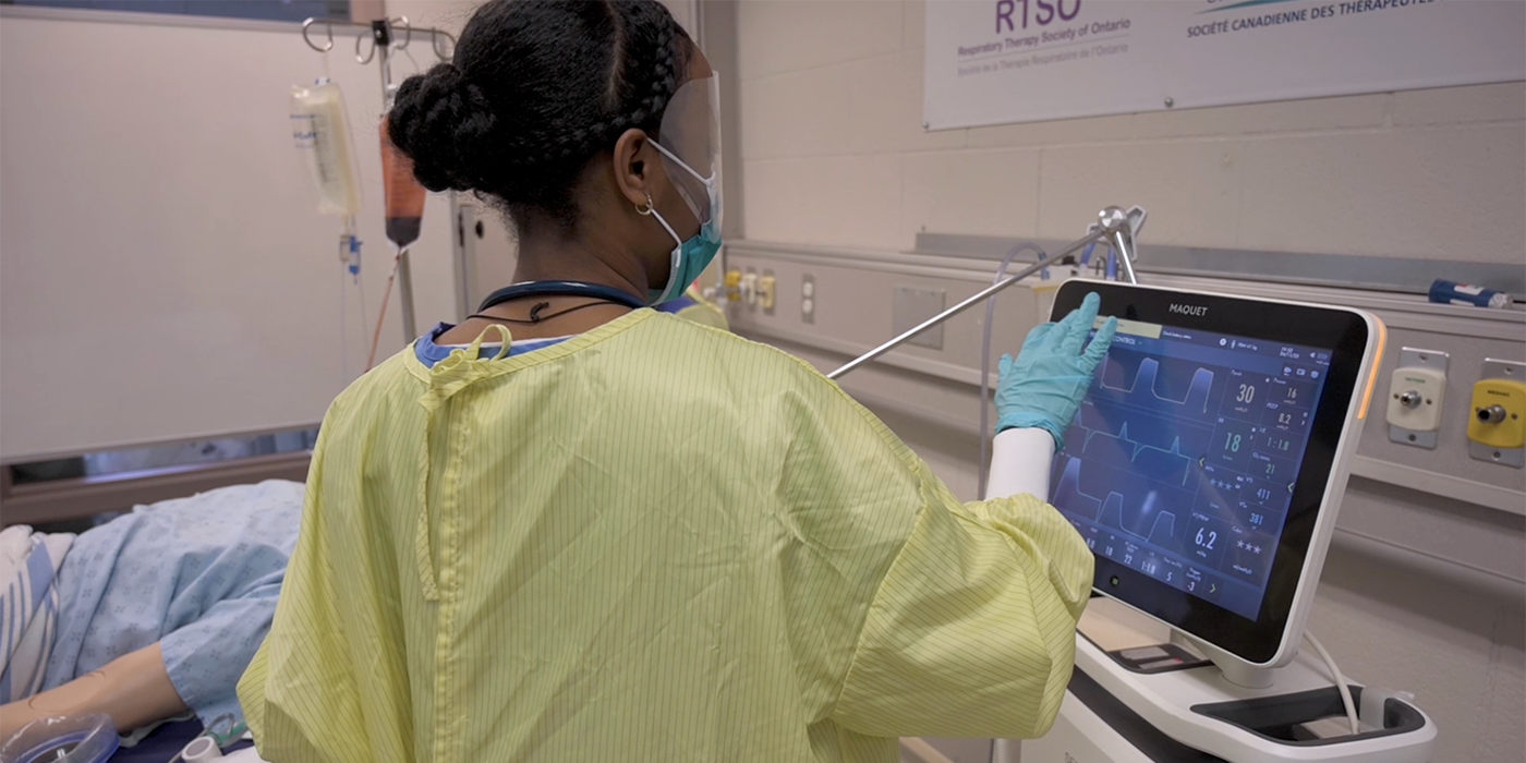 A Respiratory Therapist student works on the screen of a medical ventilator in a simulation lab at Fanshawe College