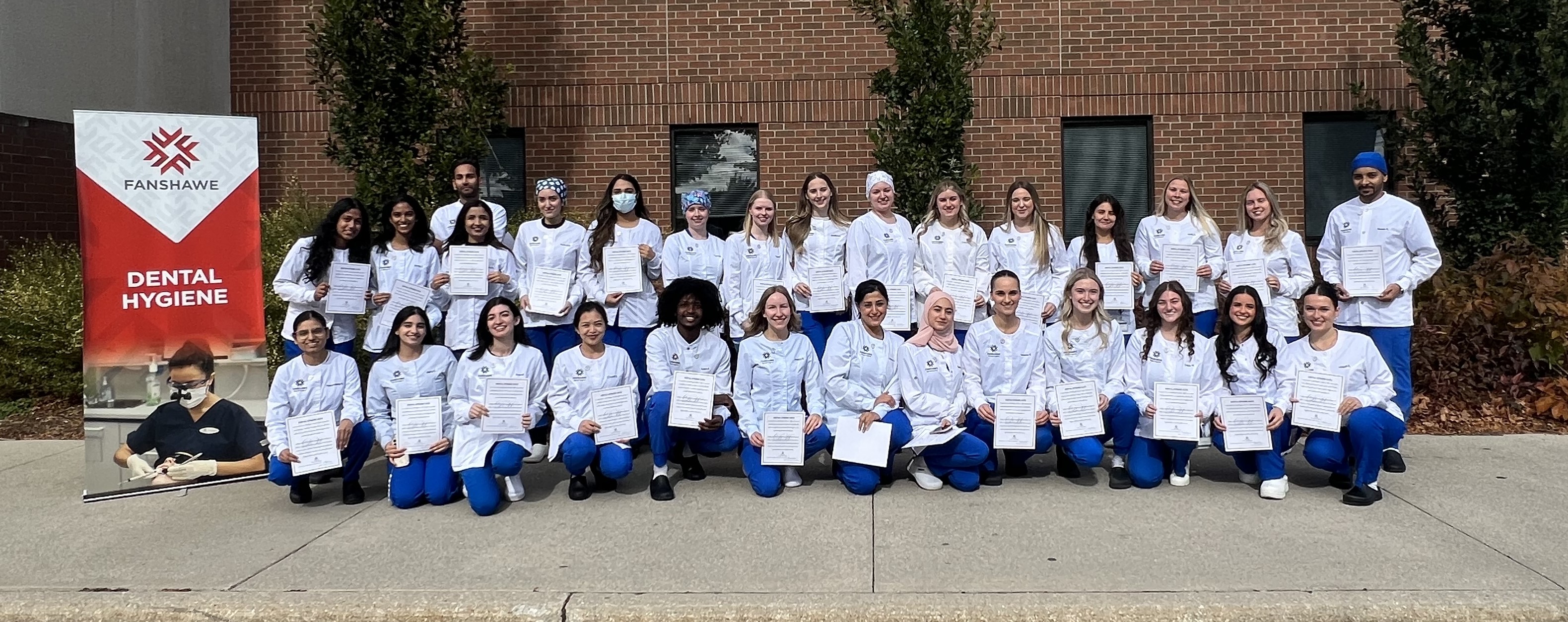 Graduating class of dental hygiene students pose for a group photo during their pinning ceremony.