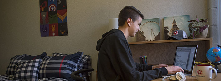 man at computer in residence room