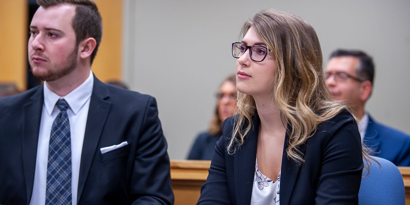 Two students in mock trial looking at judge