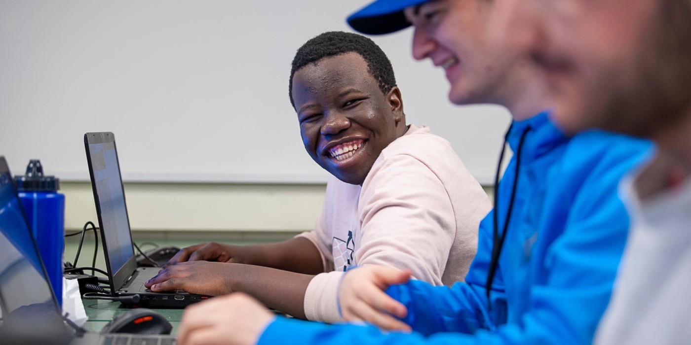 Student smiling at camera in computer lab