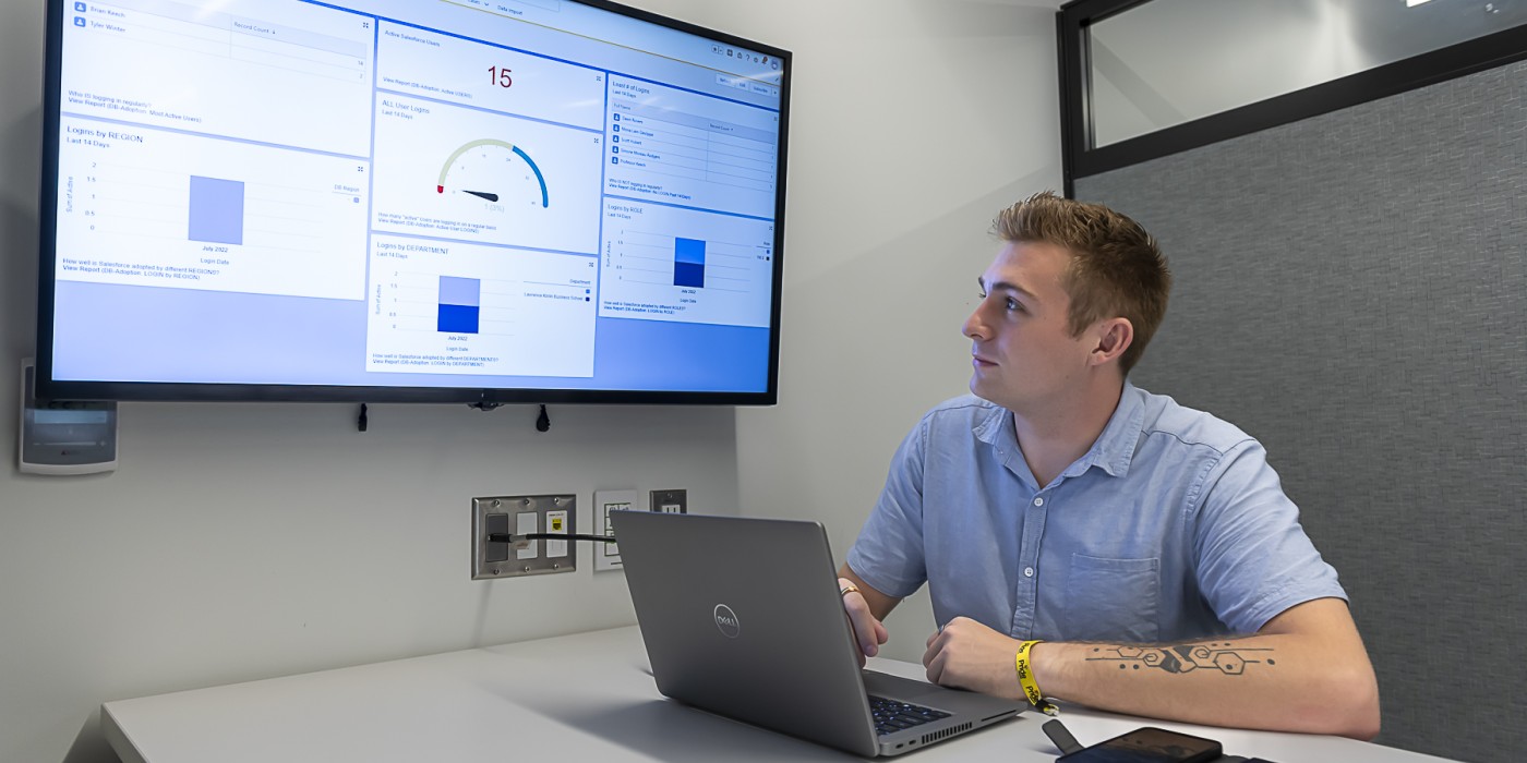 Student working on computer showing a presentation on screen