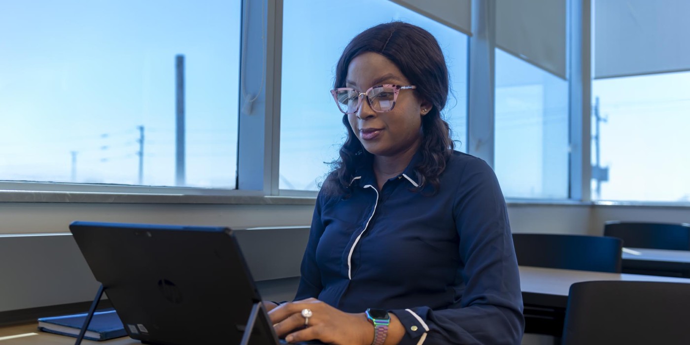 Student sitting in classroom, working on laptop
