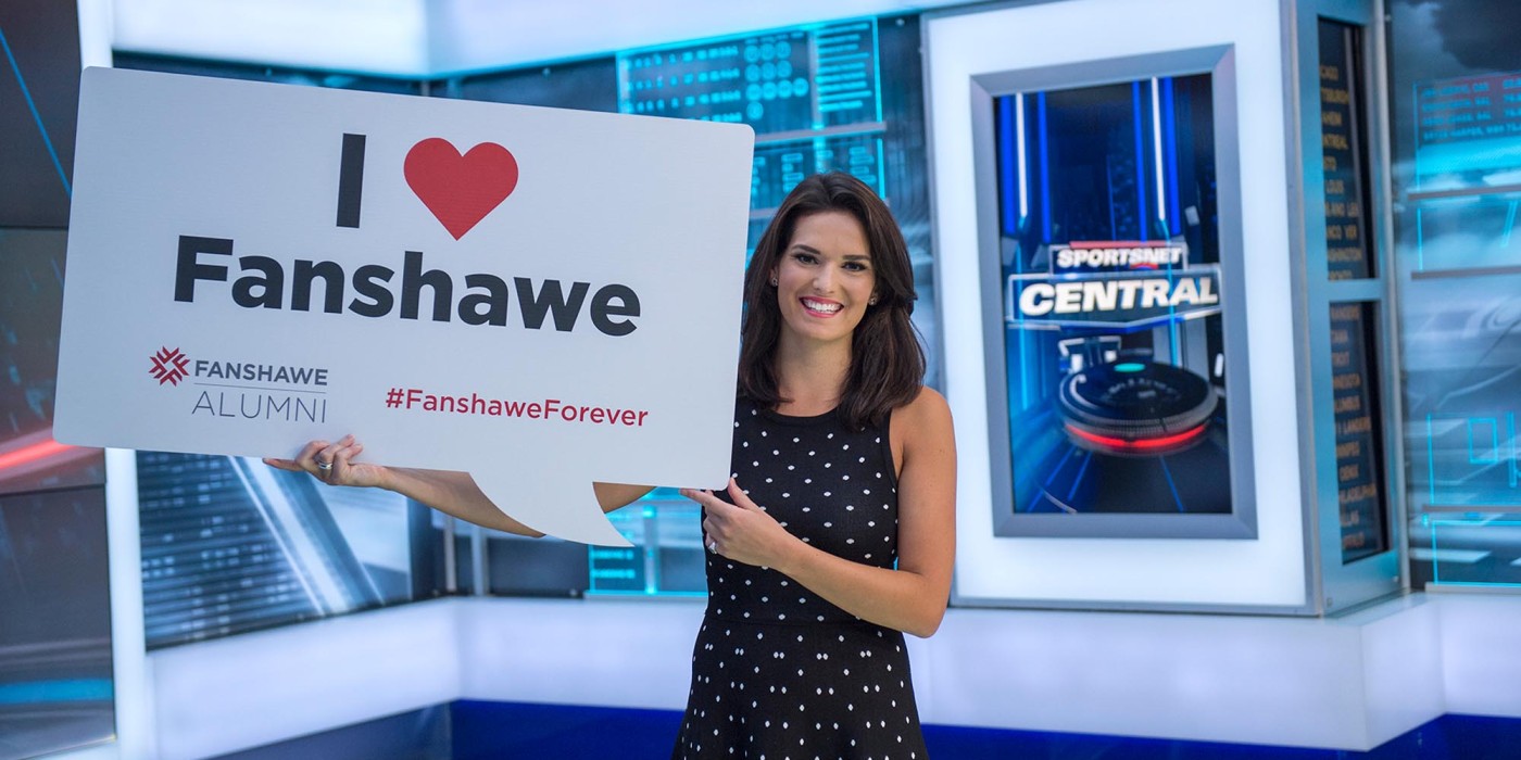 Caroline Cameron holding up the Fanshawe logo