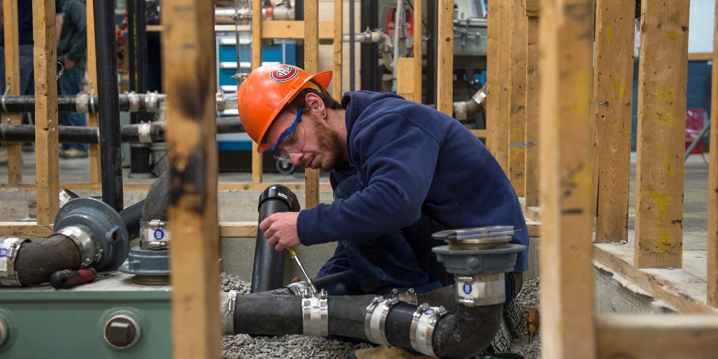 Plumbing apprentice working on a home