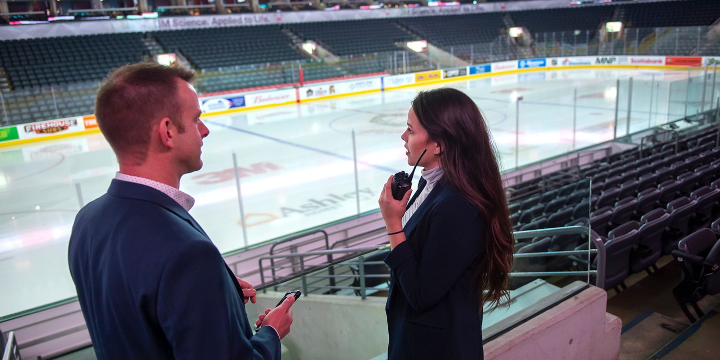Two people in an arena in suits